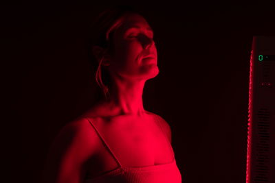 Frau vor rotem Licht in Infrarotkabine