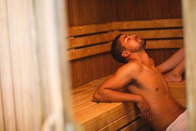 Gutaussehender Mann mit Bart entspannt in Sauna