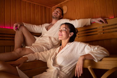 Paar in Bademänteln entspannt in Infrarotkabine