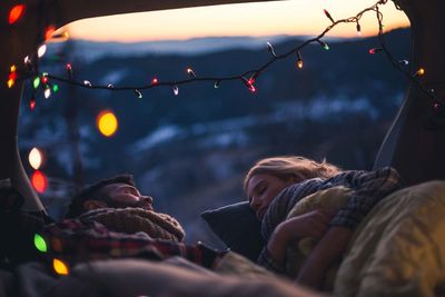 Paar schläft im Freien mit Lichtern